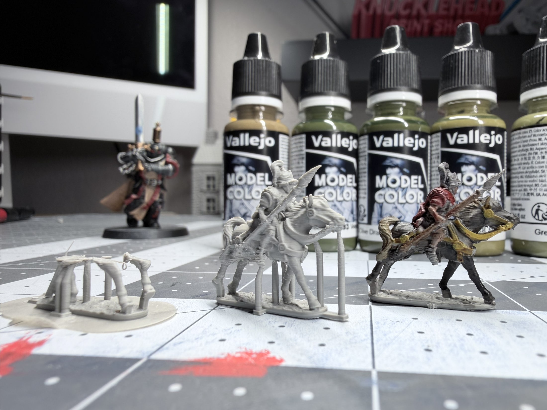 A failed 13.5mm horse print beside a successful unpainted print and a painted example